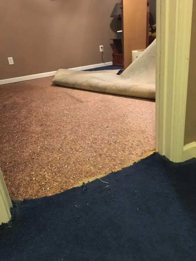 Carpet pad removal revealing water damage during Water Mitigation Services in Eagle Pass